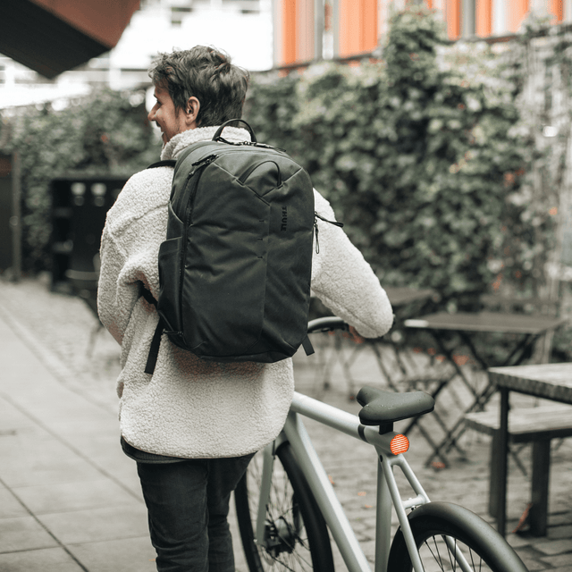 Thule Aion travel backpack 28L black worn while walking through an airport