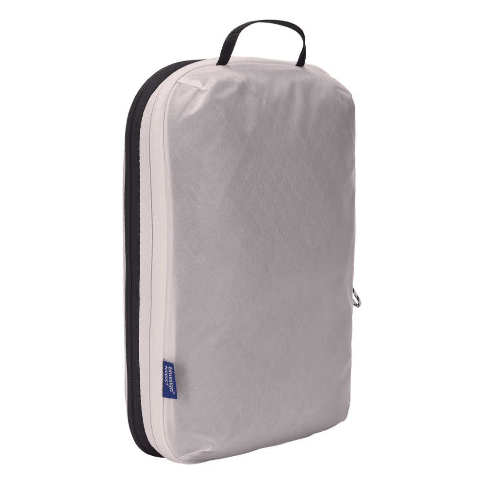 Thule compression packing cube medium in white, compressed flat with the compression zip closed