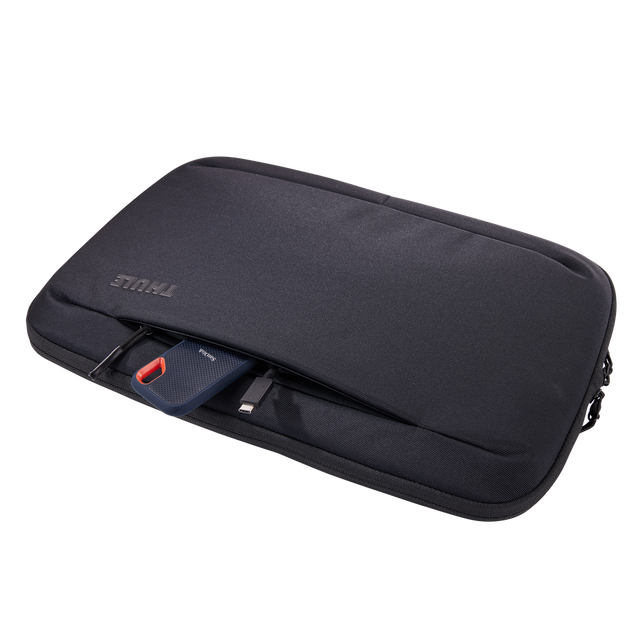 Thule Subterra 2 16in MacBook sleeve in black, laptop being lifted out of the padded compartment
