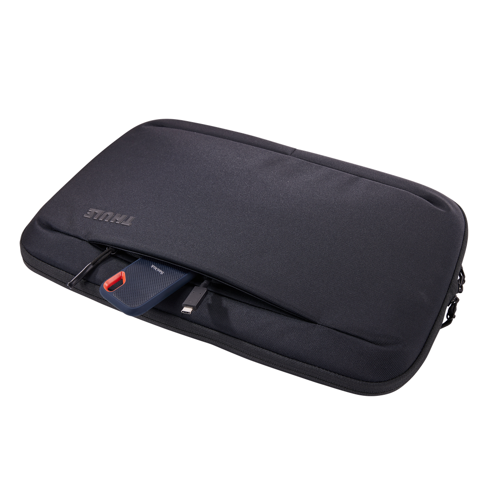 Thule Subterra 2 16in MacBook sleeve in black, laptop being lifted out of the padded compartment