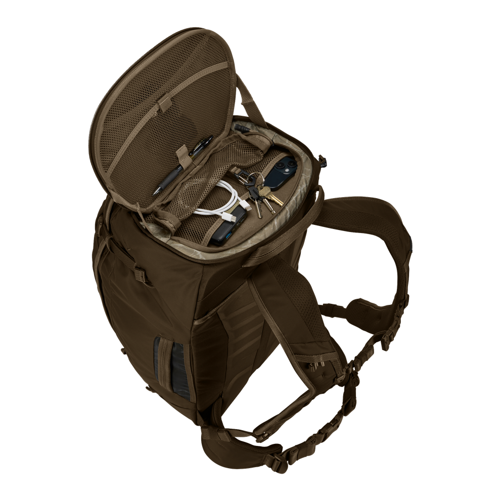 Thule Landmark 60L travel pack in deep khaki, worn on the back on a trail