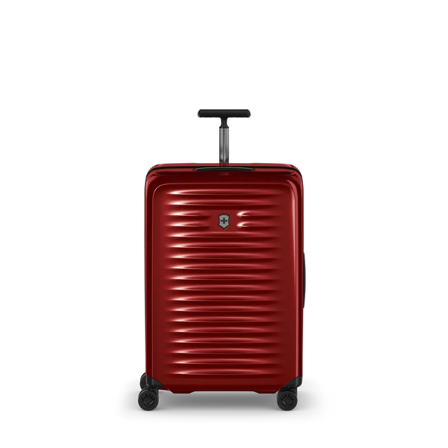Red hardshell rolling suitcase with horizontal ridges and a retractable handle.