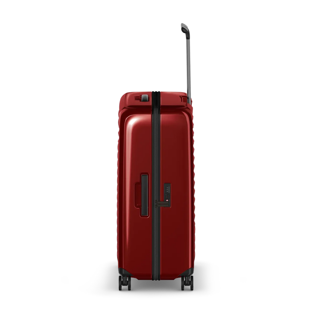 Red hardshell rolling suitcase with a telescoping handle and wheels.