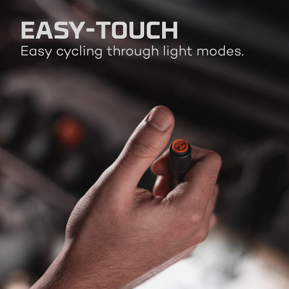 A hand holding a small electronic device or button with an orange indicator light.