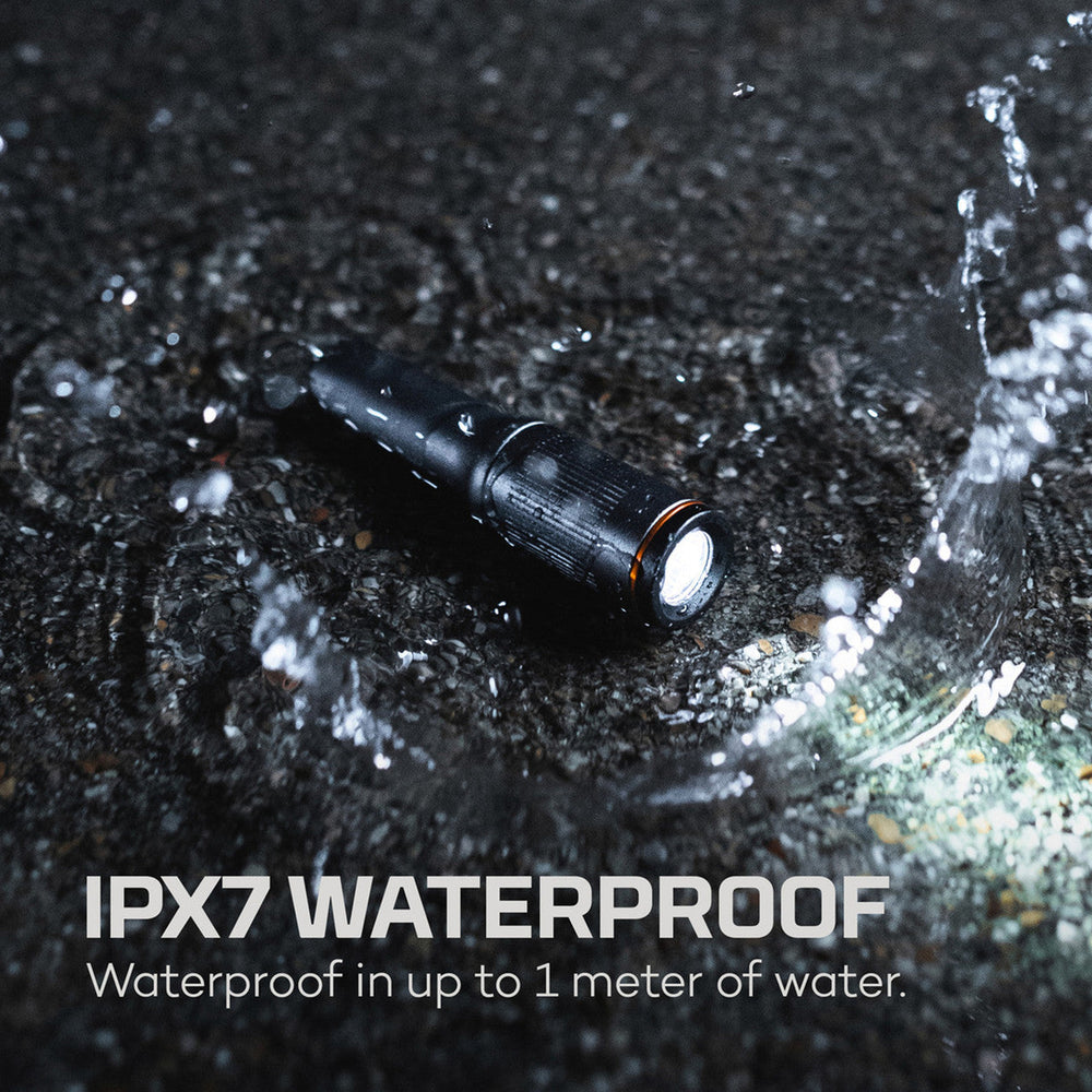 Black waterproof flashlight with water splashing around it.