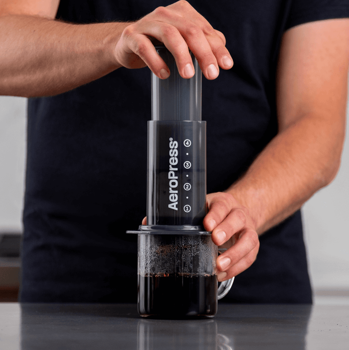 AeroPress coffee maker being used to brew coffee.