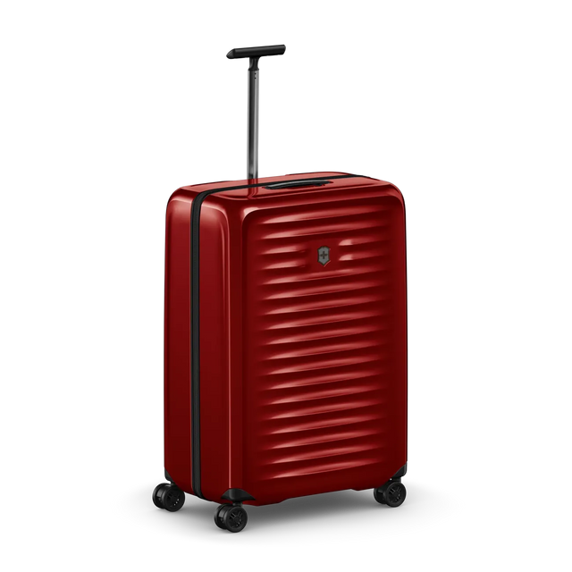 Red hardshell rolling suitcase with horizontal ridges and a retractable handle.
