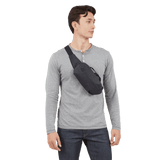 Thule Aion sling bag black worn crossbody over a jacket