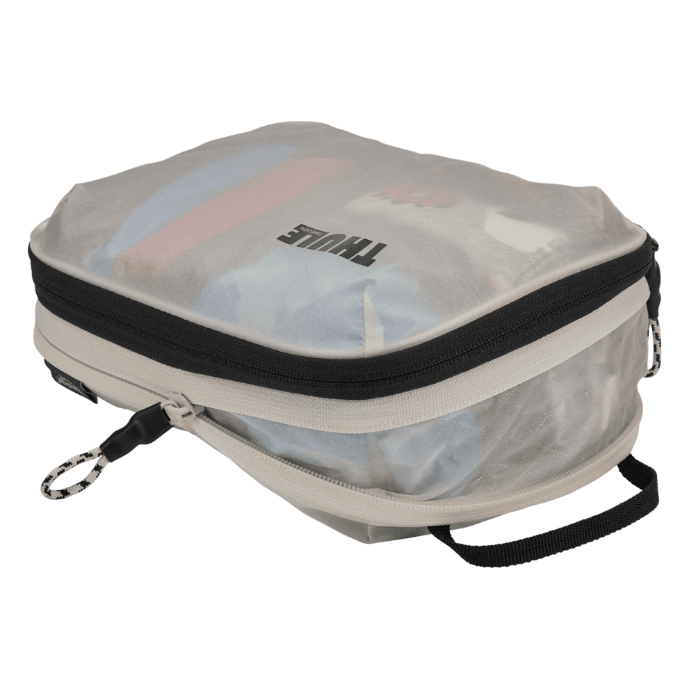Thule compression packing cube small in white, expanded and loaded with rolled t-shirts