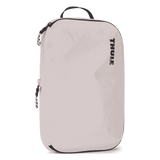 Thule compression packing cube medium in white, angled view showing the webbing handle