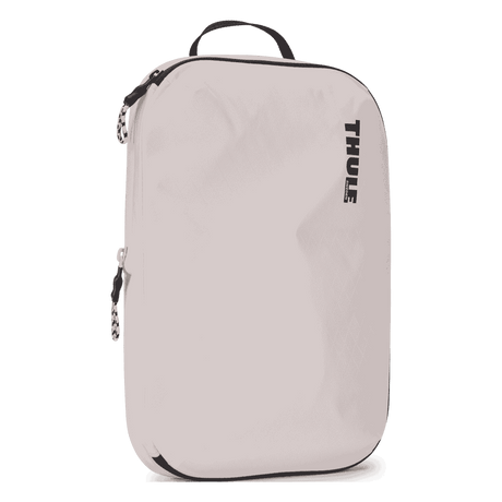 Thule compression packing cube medium in white, angled view showing the webbing handle