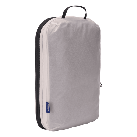 Thule compression packing cube medium in white, compressed flat with the compression zip closed