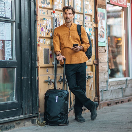 Thule Chasm carry-on wheeled duffel 40L black in an airport terminal
