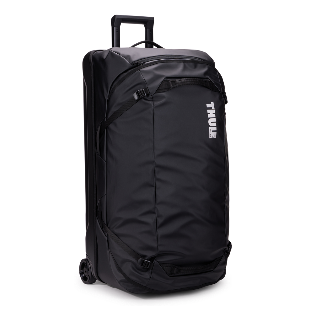 Thule Chasm rolling duffel 110L black, angled view with handle extended