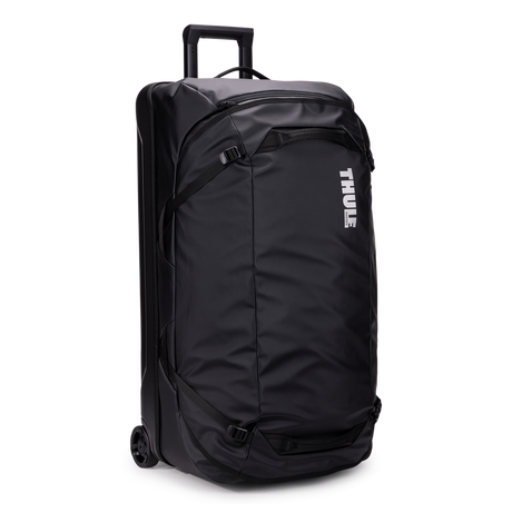 Thule Chasm rolling duffel 110L black, angled view with handle extended