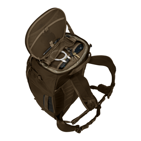 Thule Landmark 60L travel pack in deep khaki, worn on the back on a trail