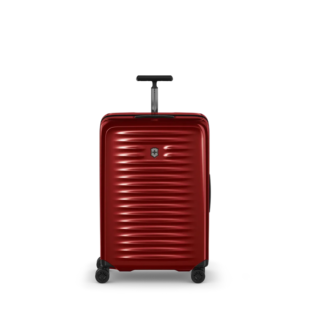 Red hardshell rolling suitcase with horizontal ridges and a retractable handle.