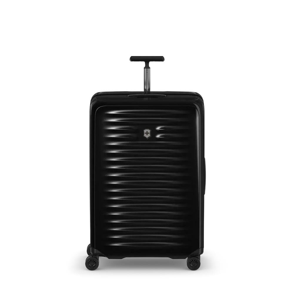 Black hardshell rolling suitcase with horizontal ribbed texture and extendable handle.
