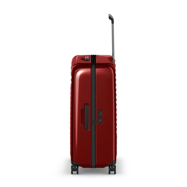 Red hardshell rolling suitcase with a telescoping handle and wheels.