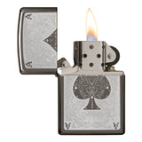 Ornate metal lighter with an engraved spade symbol and flame lit.