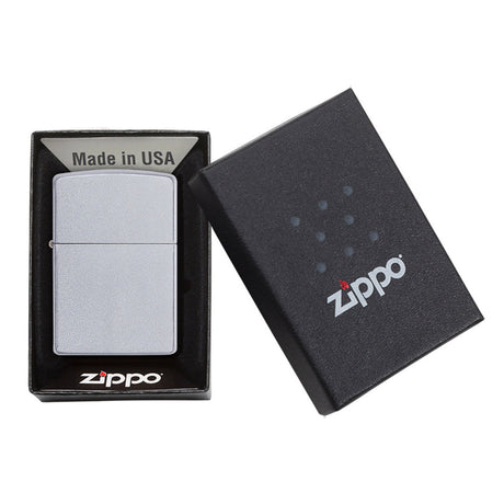 Zippo lighter in its packaging, consisting of a metal lighter and a black box with the Zippo logo.