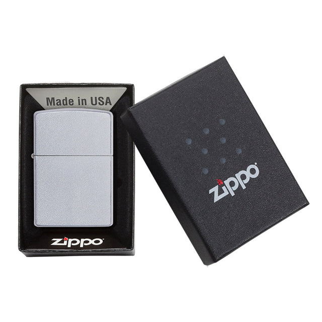 Zippo lighter in its packaging, consisting of a metal lighter and a black box with the Zippo logo.