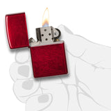Red metallic lighter with an open flame.
