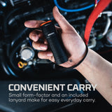 Handheld flashlight with a lanyard attached, held in a person’s hand.