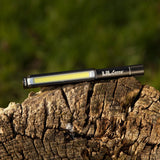 Slim black flashlight with a bright LED strip along its length.