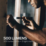 Handheld flashlight being operated in a dimly lit environment.