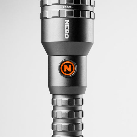 Sleek, metallic flashlight with an orange ’N’ logo and multiple adjustment rings.