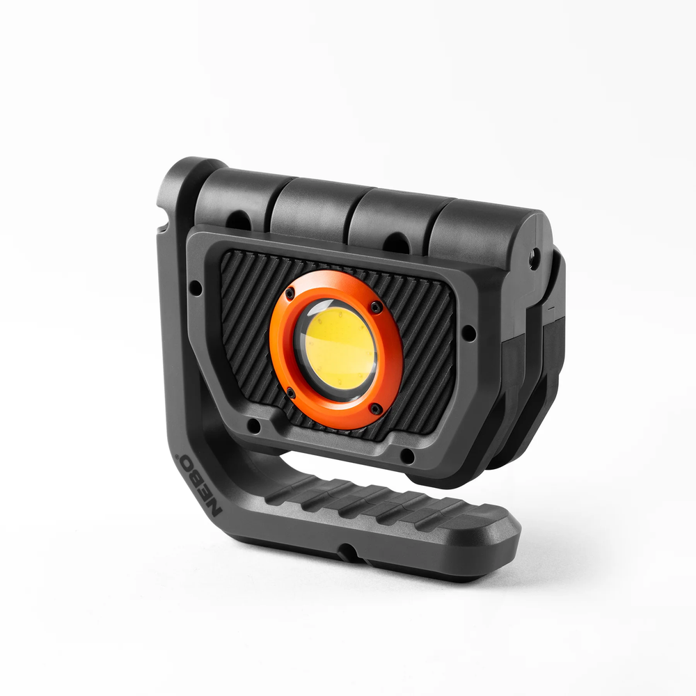 Portable LED work light with a rugged black housing and orange-rimmed circular light.