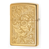 Gold-colored Zippo lighter with an intricate floral engraving pattern on its surface.