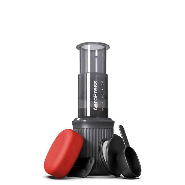 Portable coffee maker with a cylindrical brewing chamber and red filter cap.
