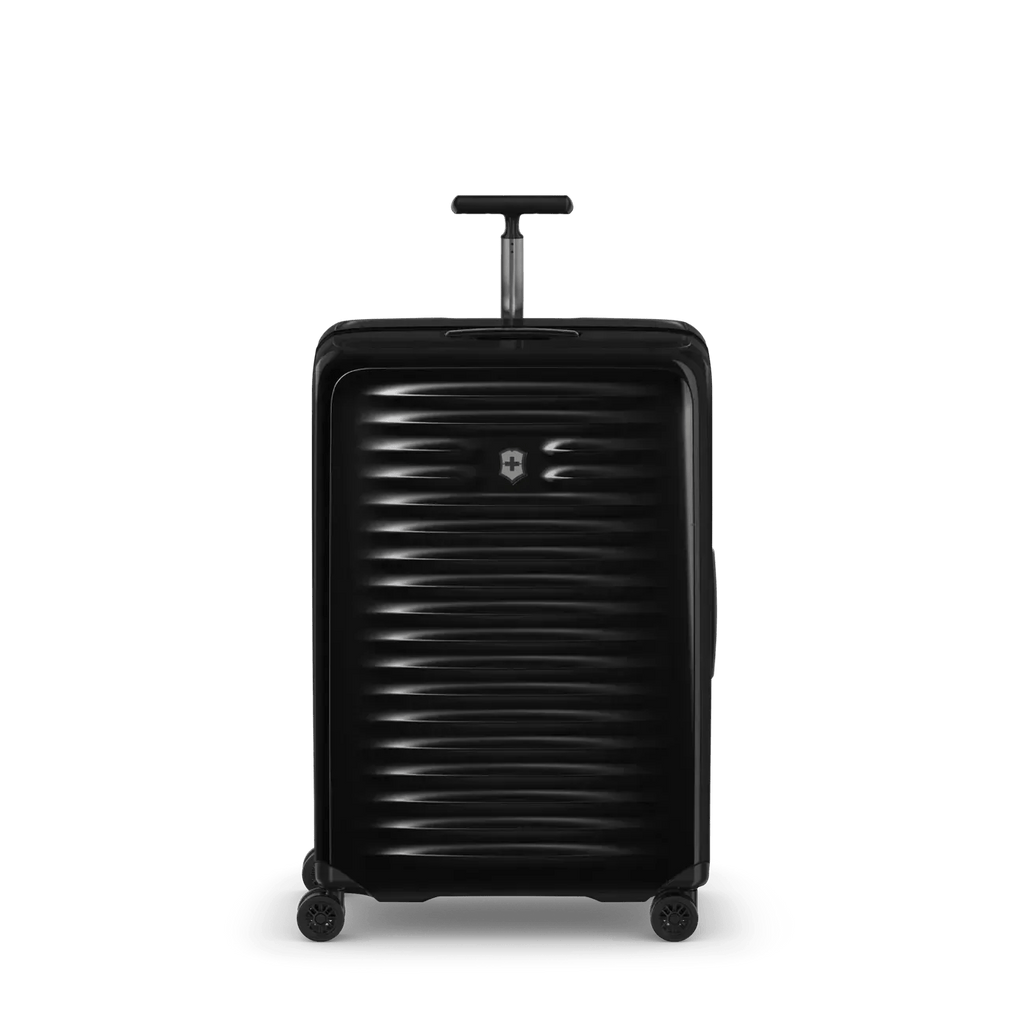 Black hardshell rolling suitcase with horizontal ribbed texture and extendable handle.