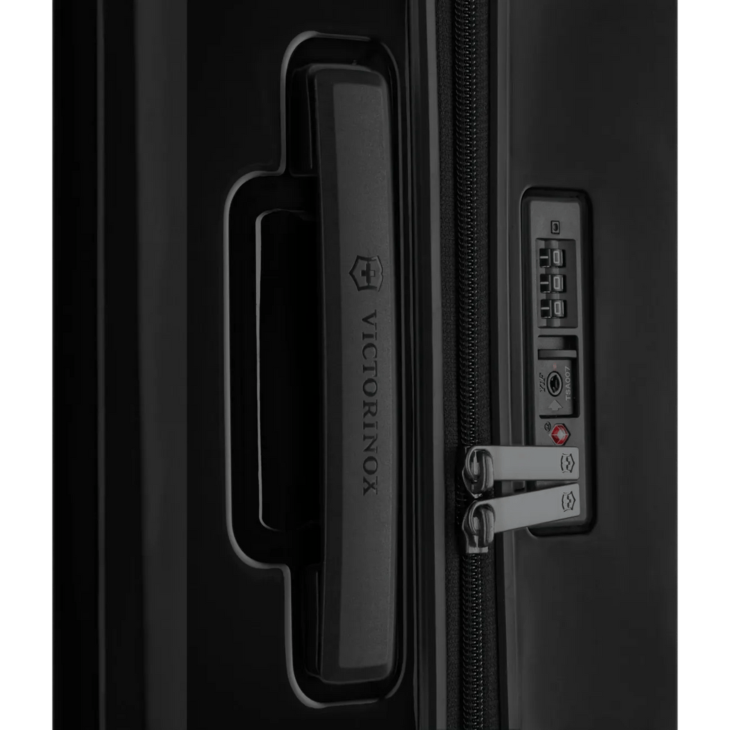 Luggage handle and combination lock on a black suitcase.
