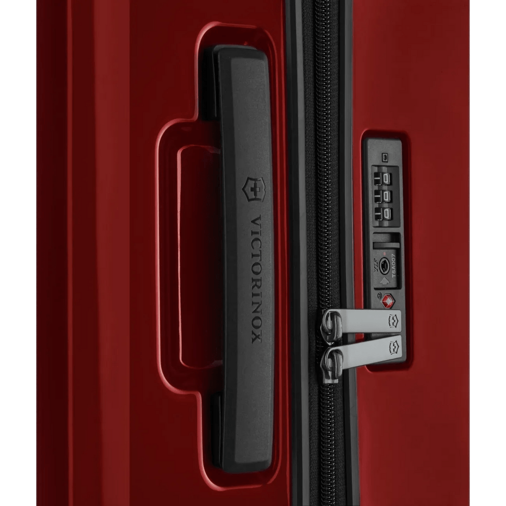 Red hardshell suitcase with a combination lock and zipper.