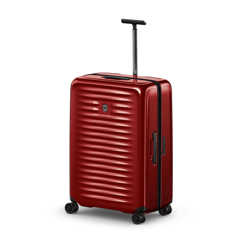 Red hardshell rolling suitcase with horizontal ridges and a retractable handle.