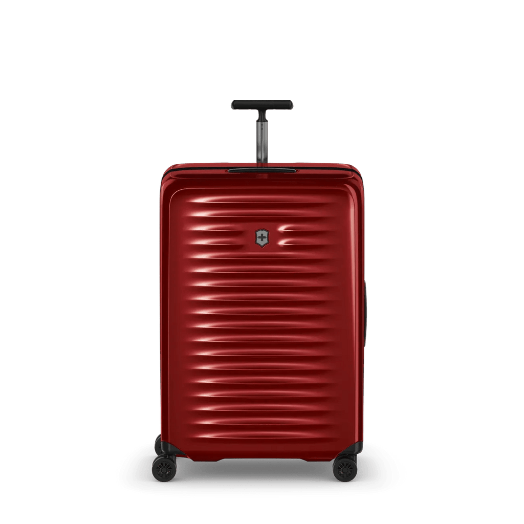 Red hardshell rolling suitcase with horizontal ridges and a retractable handle.