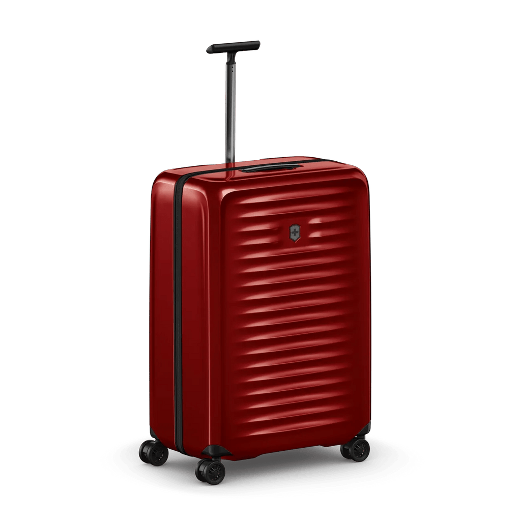 Red hardshell rolling suitcase with horizontal ridges and a retractable handle.
