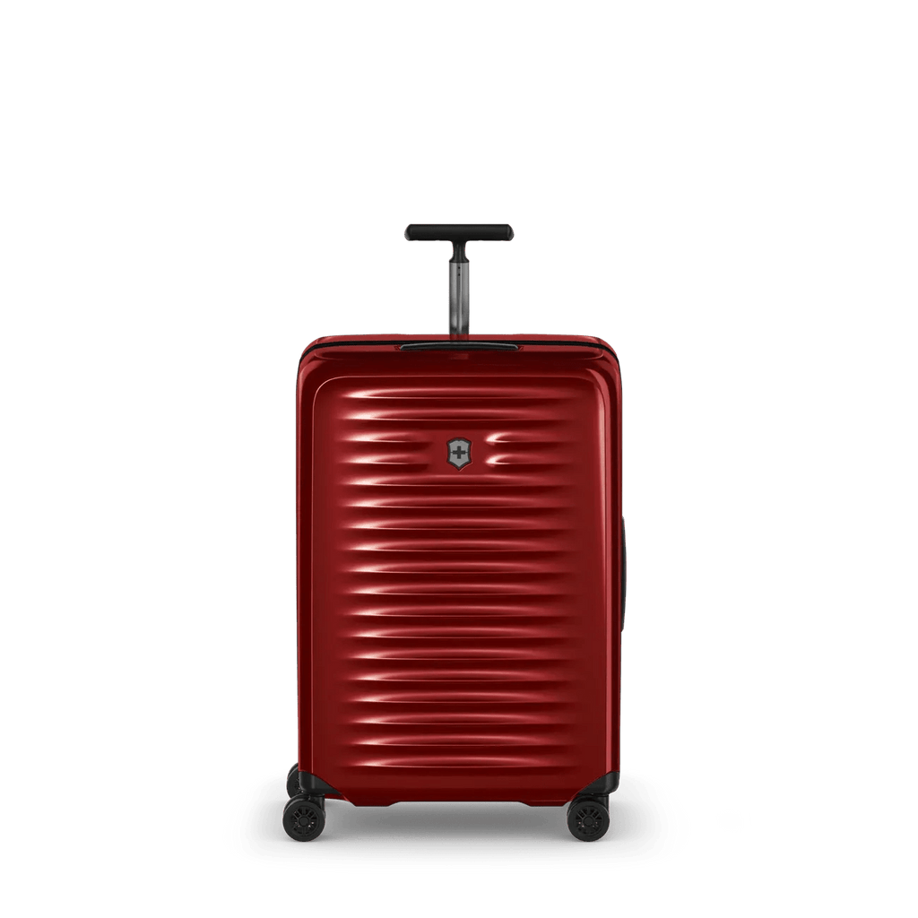 Red hardshell rolling suitcase with horizontal ridges and a retractable handle.