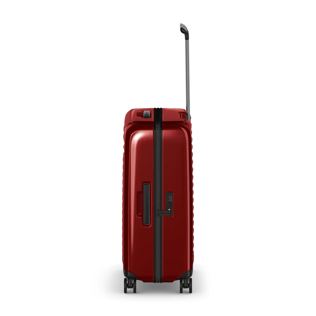Red hardshell rolling suitcase with an extendable handle and wheels.